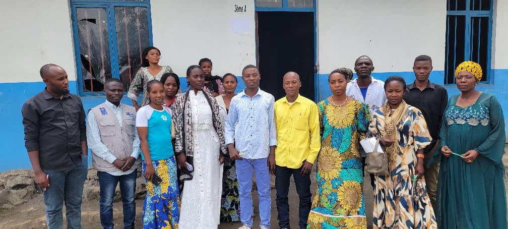 Membres de la communauté réunis devant l'école lors d'une activité de SAPI en RDC
